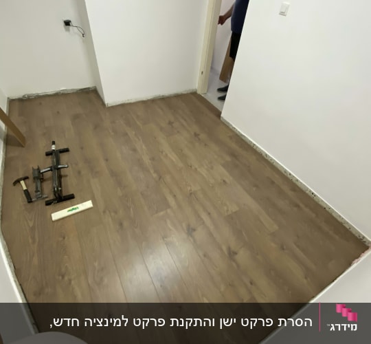 חדר עם פרקט עץ וכלי עבודה על הרצפה